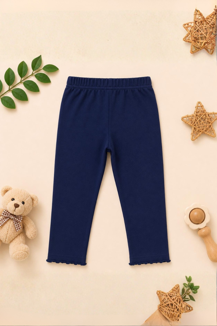 Navy blue leggings on a beige background with decorative elements.
