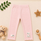 Pink baby leggings with decorative elements on a beige background
